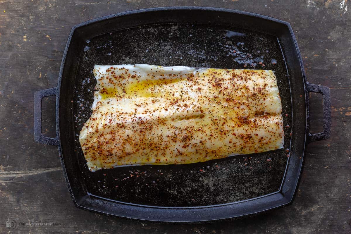 A sea bass fillet in a black pan