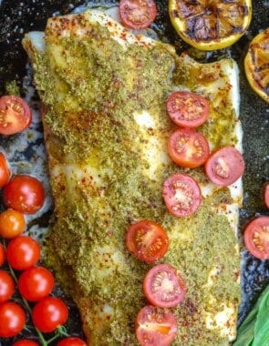 Baked sea bass topped with pesto and grape tomato halves