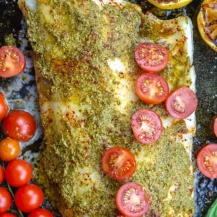 Baked sea bass topped with pesto and grape tomato halves