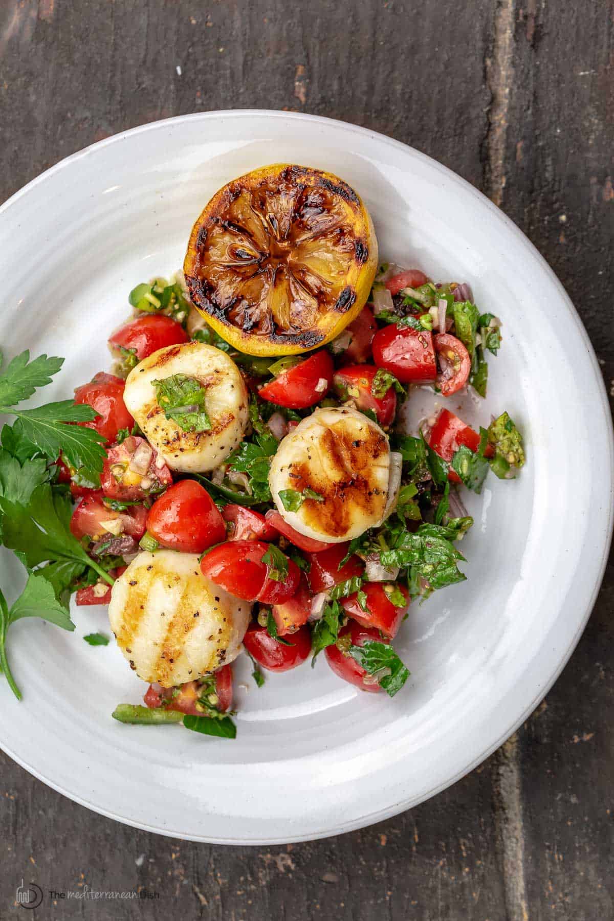 A plate of scallops over salsa