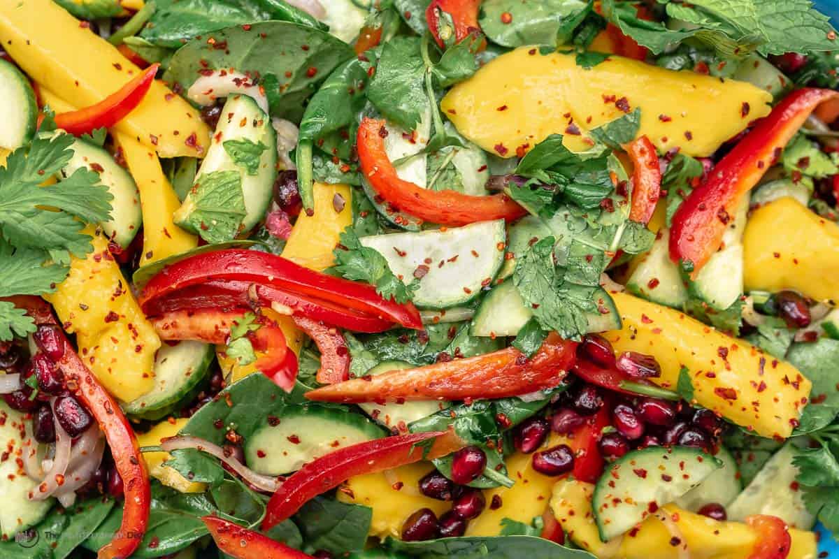 A close-up of healthy mango salad with spinach