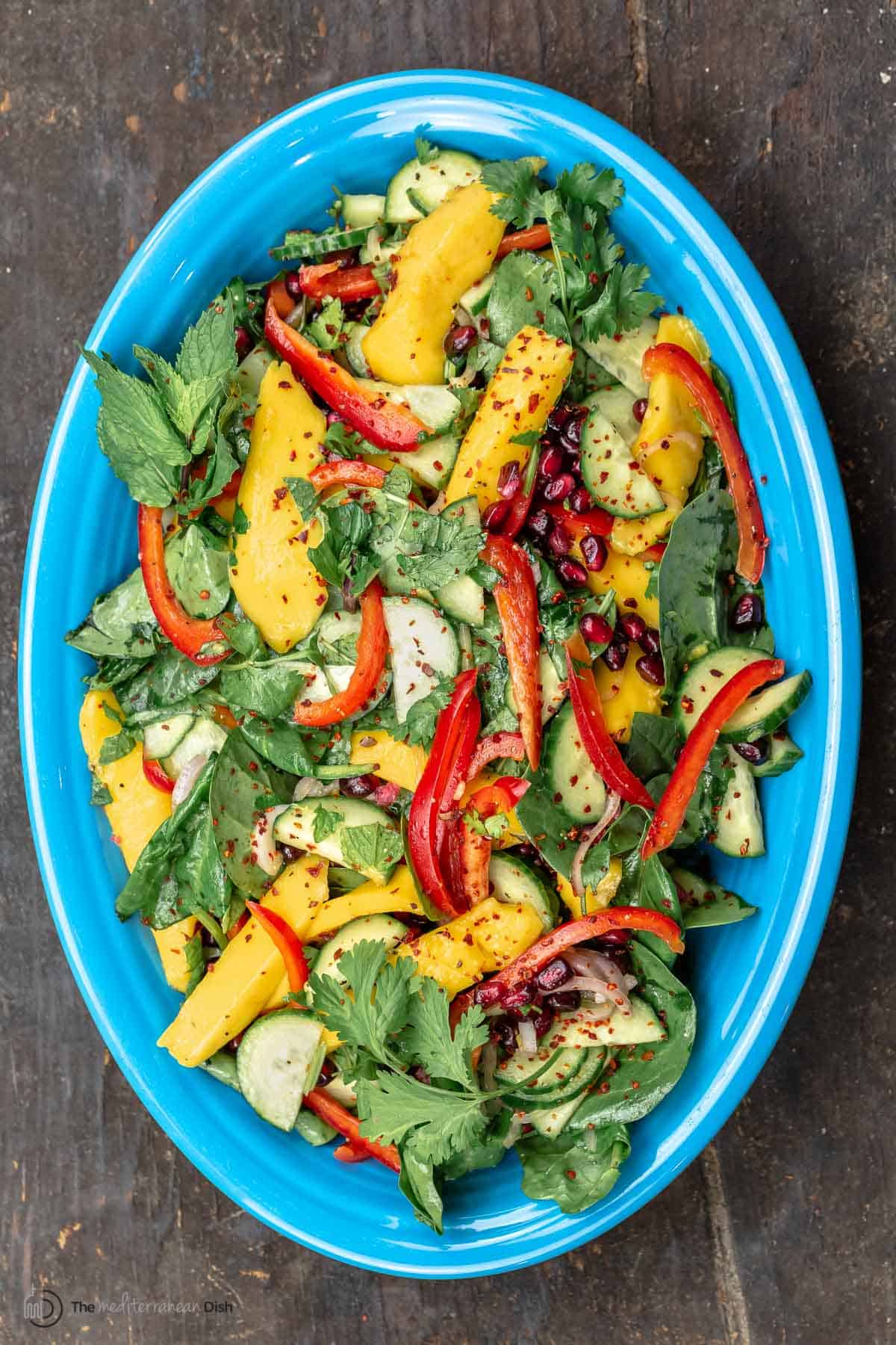 Healthy mango salad on a blue serving plate