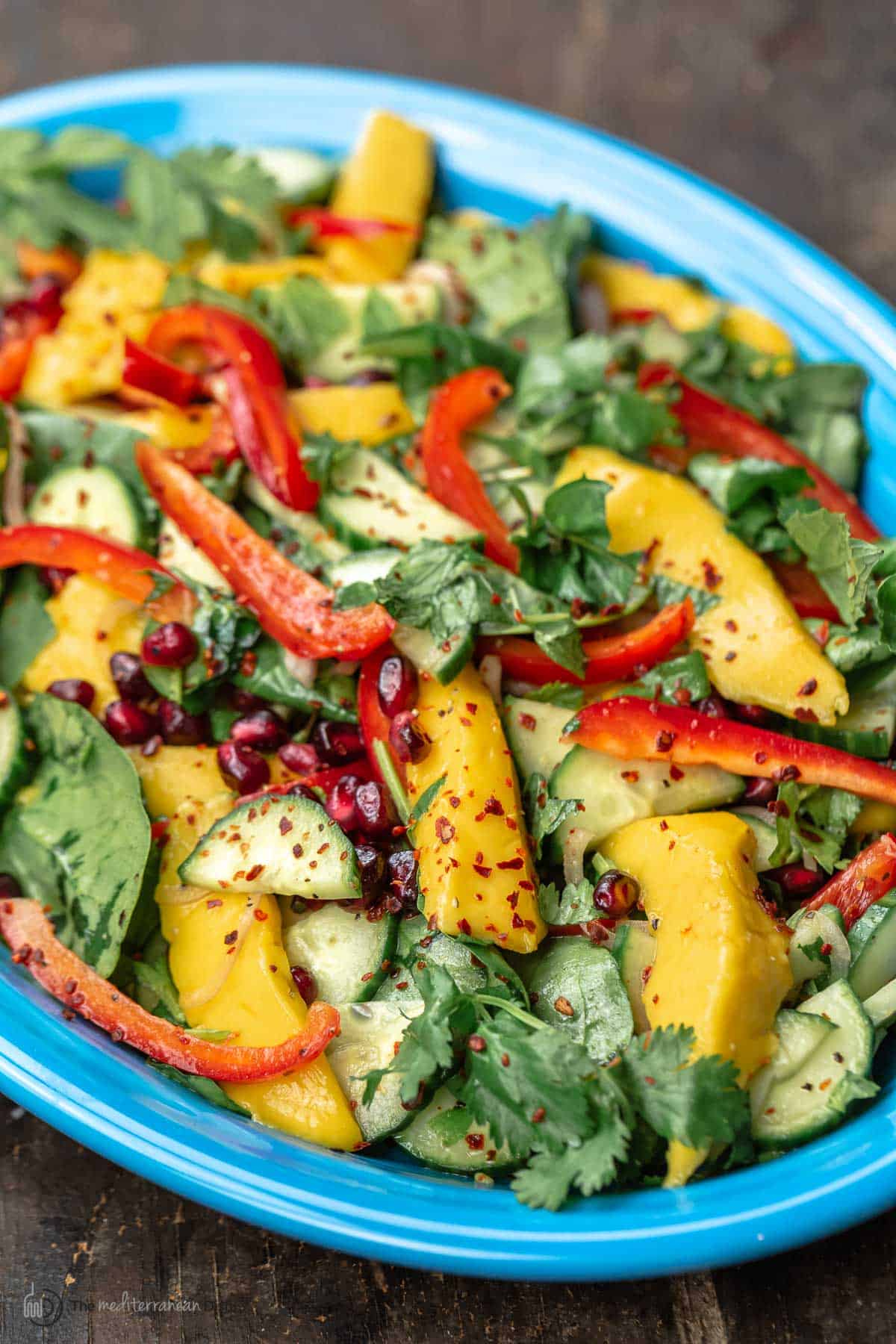 Savory mango salad on a blue plate