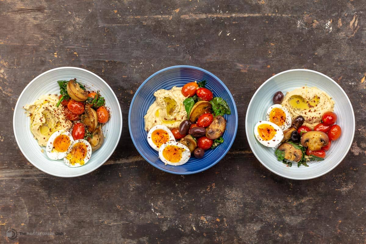 3 Mediterranean savory breakfast bowls with soft-boiled eggs, sauteed vegetables and hummus