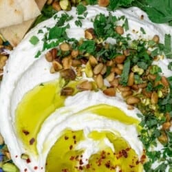 A close-up of whipped feta with olive oil, pine nuts, pistachios and herbs
