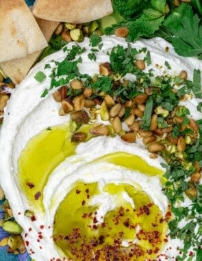 A close-up of whipped feta with olive oil, pine nuts, pistachios and herbs