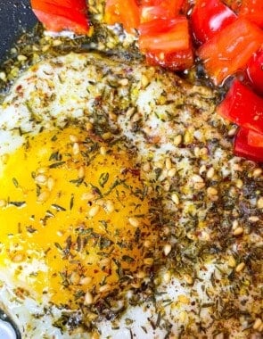 fried eggs with olive oil and za'atar and a side of chopped cherry tomatoes