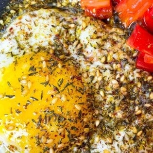 fried eggs with olive oil and za'atar and a side of chopped cherry tomatoes