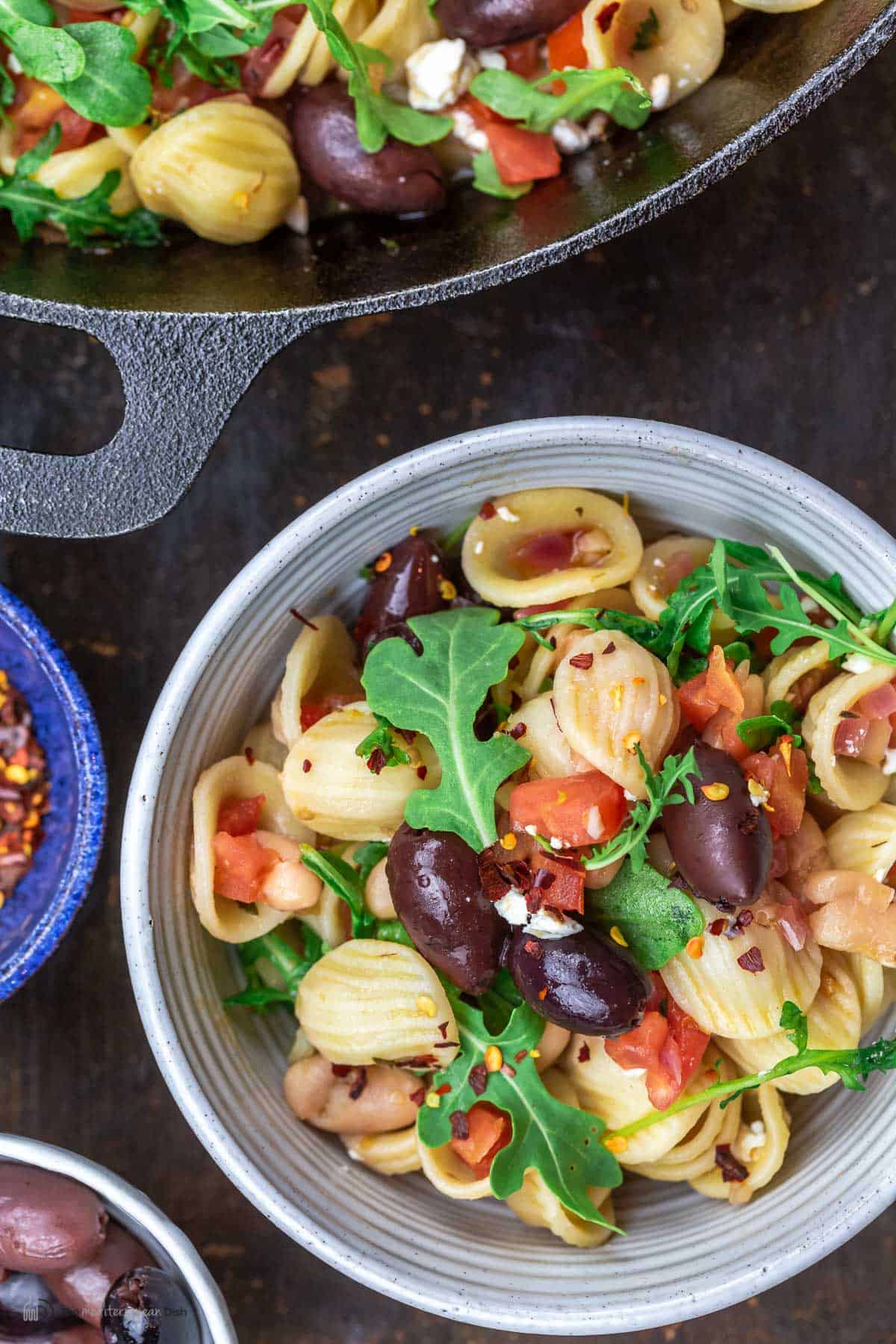 orecchiette pasta in a bowl and a skillet next to it