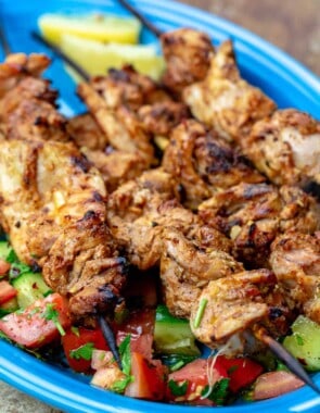 Chicken tawook grilled chicken skewers on a blue plate with salad