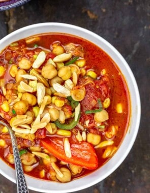 A big bowl of chickpea chili topped with toasted almonds