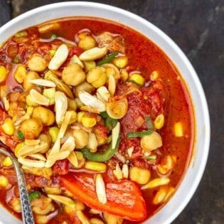 A big bowl of chickpea chili topped with toasted almonds