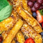 Fried halloumi on a plate with fruit and honey