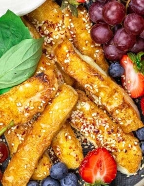 Fried halloumi on a plate with fruit and honey