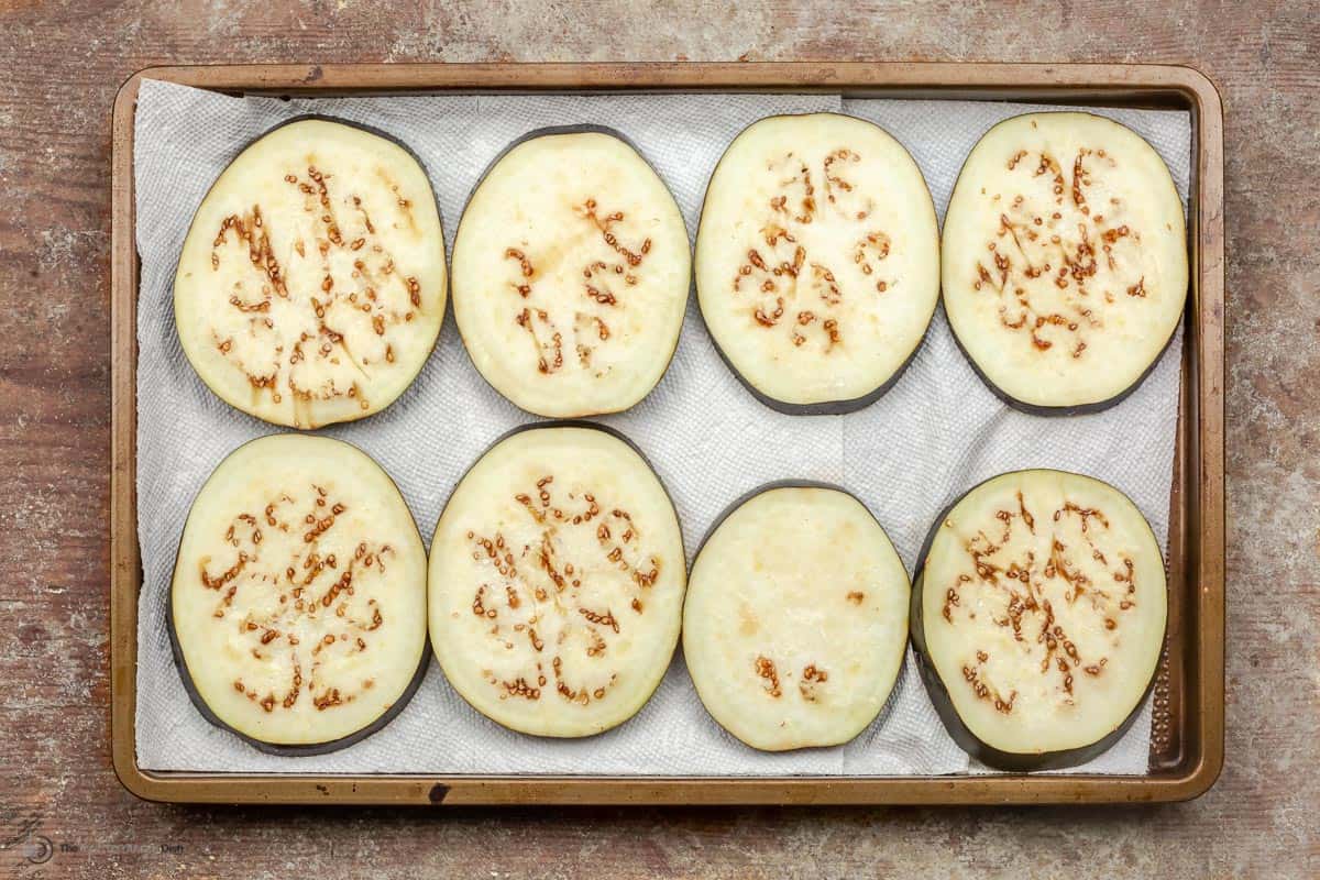 Salt eggplant slices on a baking tray