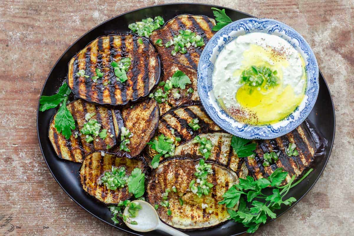 Mediterranean grilled eggplant slices on a plate with whipped feta dip