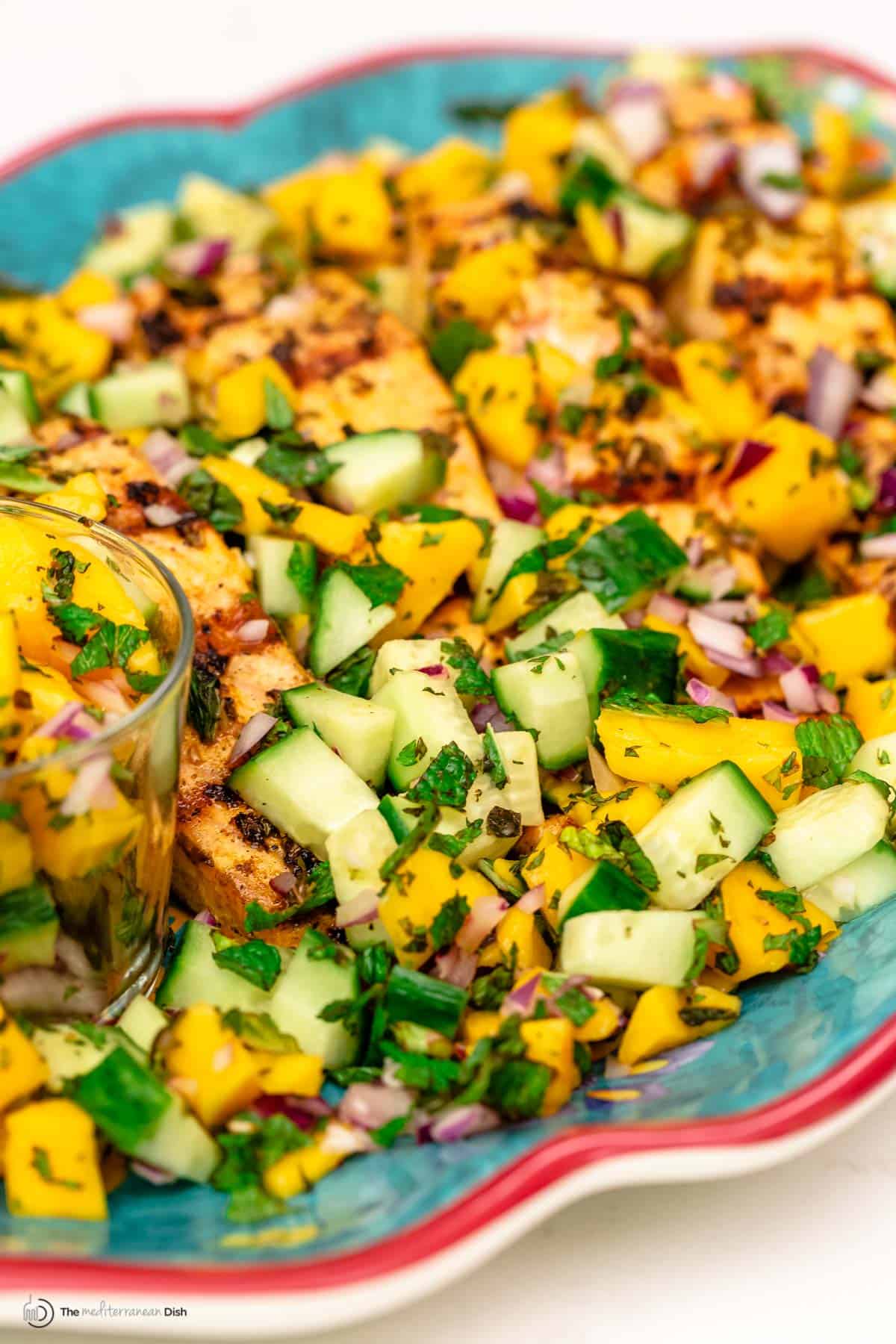 Salmon grilled and served on a plate with mango salad