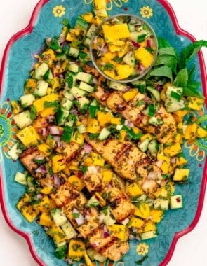 Grilled salmon served on a large plate with mango salad