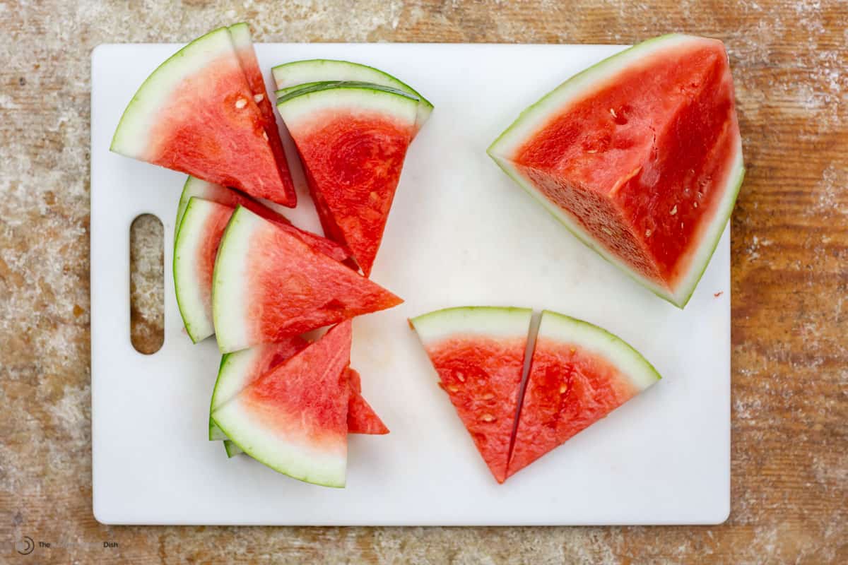 Watermelon slices into triangles on a cutting board