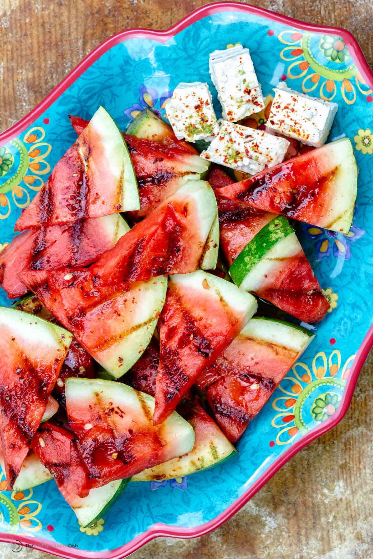 Grilled watermelon slices and feta on a blue plate