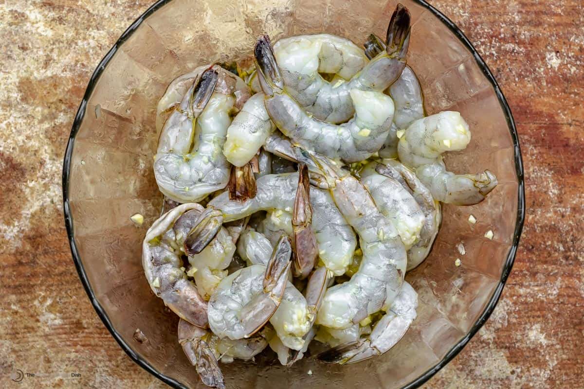 Raw shrimp marinating in olive oil and garlic