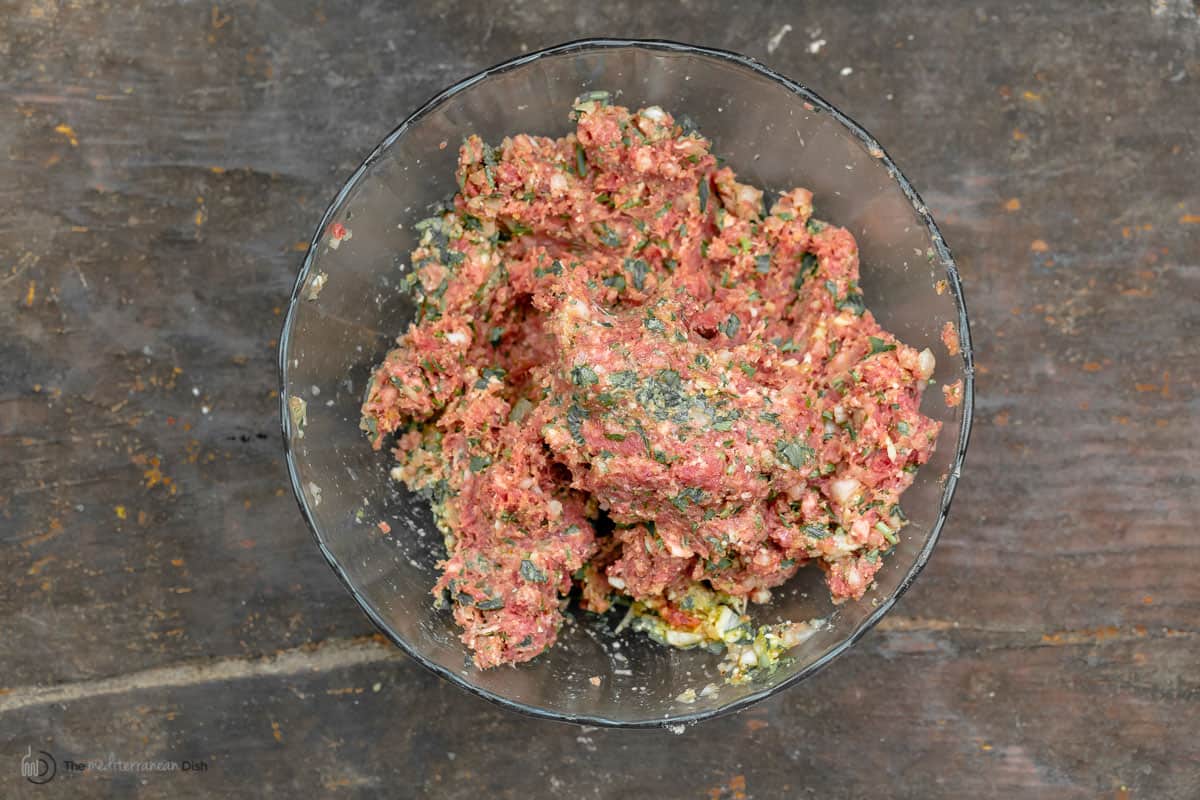 Homemade meatball mixture in a white baking dish