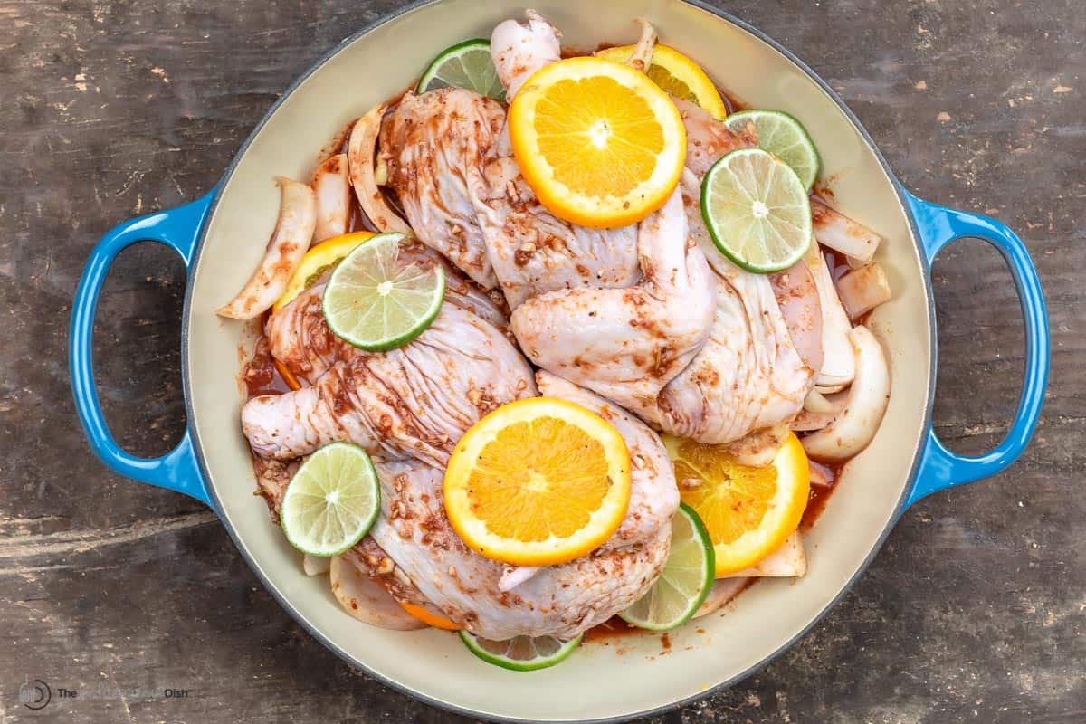 Marinated chicken with orange and lemon slices in the pan ready to bake