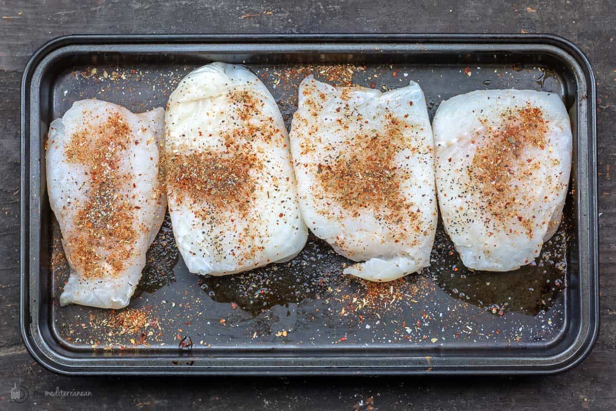 Haddock fillets with spices on a baking sheet