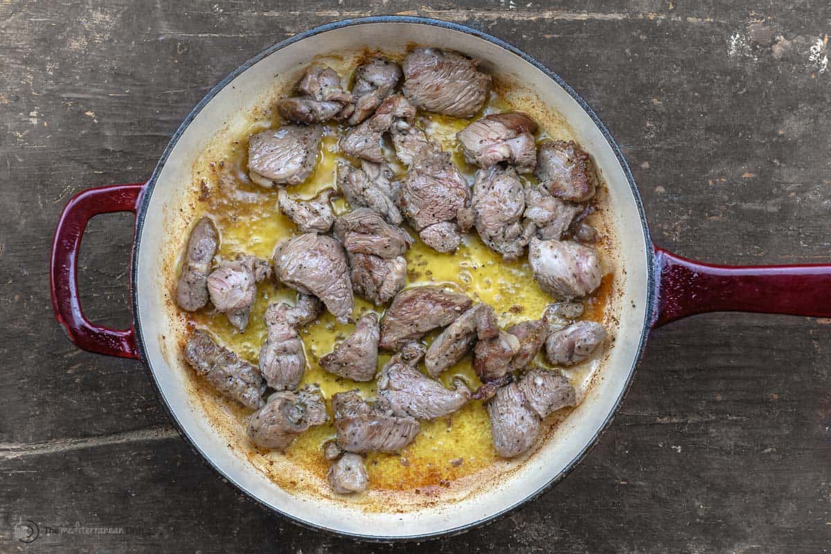 Chunks of lamb being sauteed in olive oil