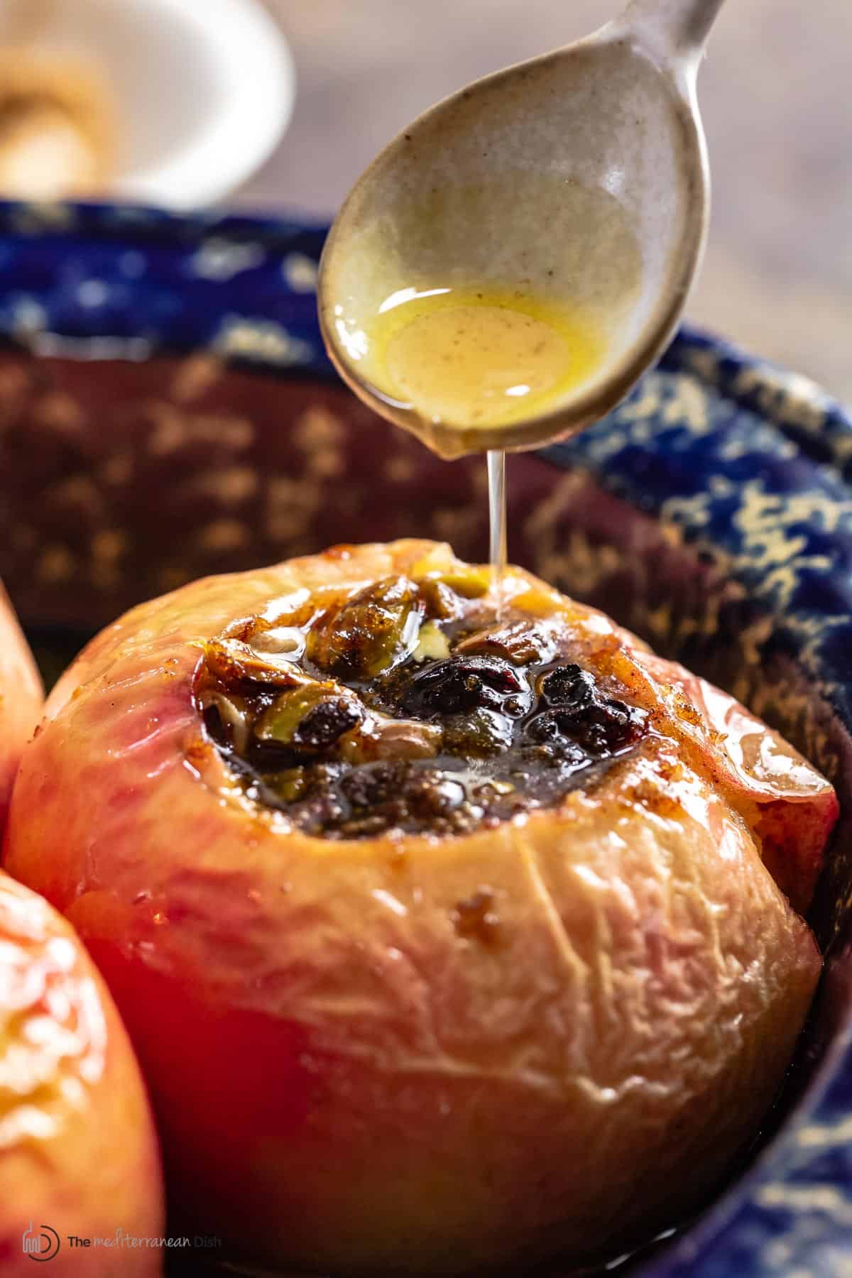 Brown sugar sauce being drizzled over baked apples