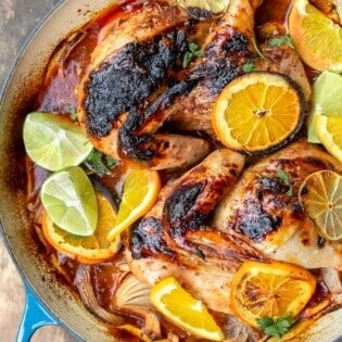Roasted chicken with rosemary and citrus slices in a braiser