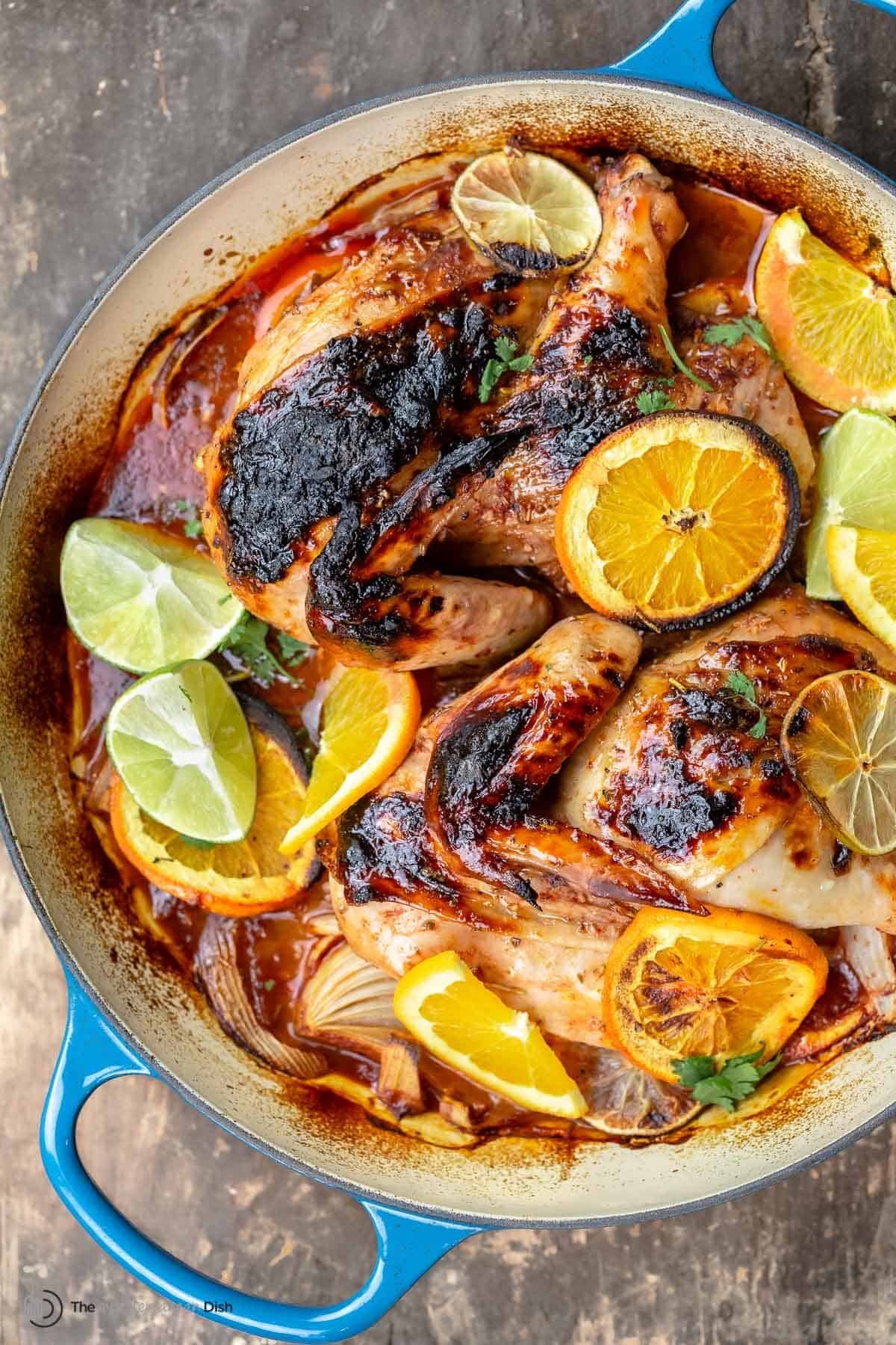 Roasted chicken with rosemary and citrus slices in a braiser