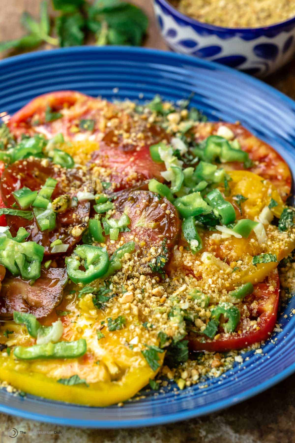 fresh tomato salad with a side of dukkah in a bowl 