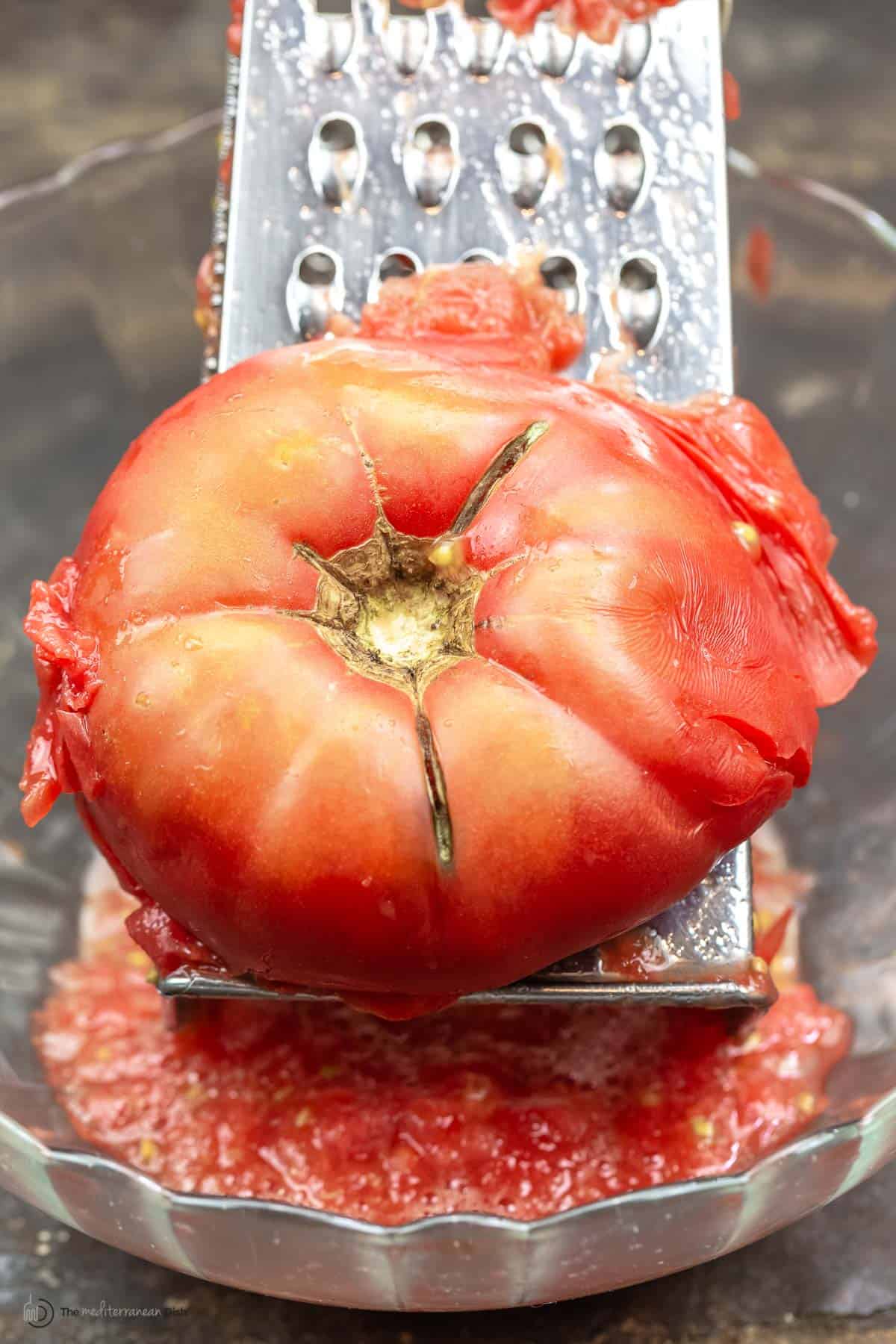 Close up of a tomato over a hand grater