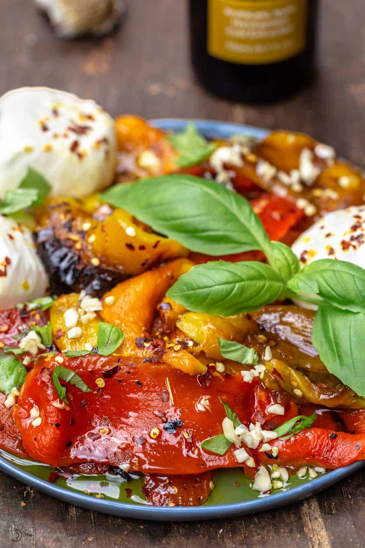 Roasted red peppers on a tray with burrata