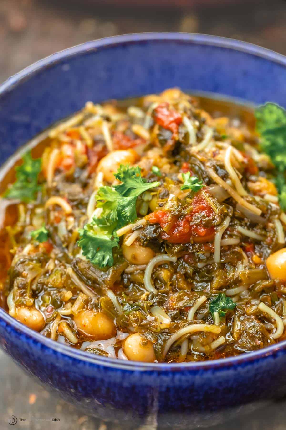 A blue bowl of Mediterranean spinach stew