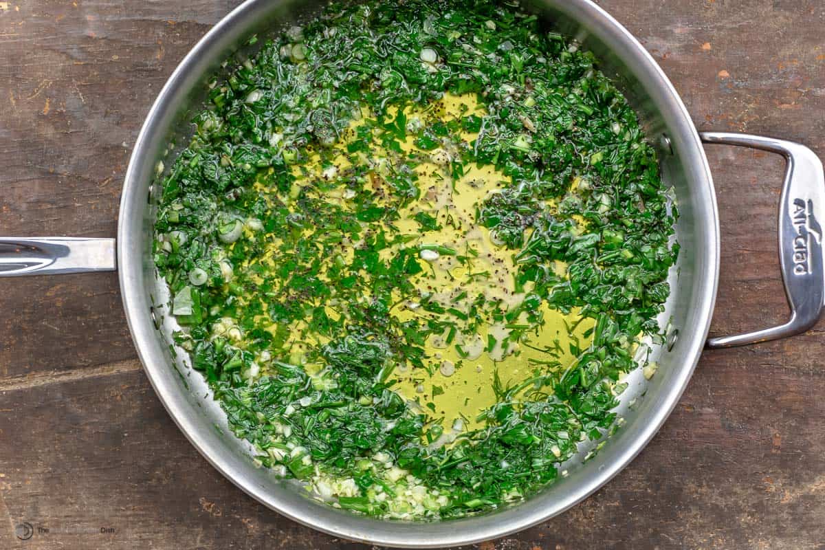 Fresh parsley and dill sauteed in a pan with olive oil