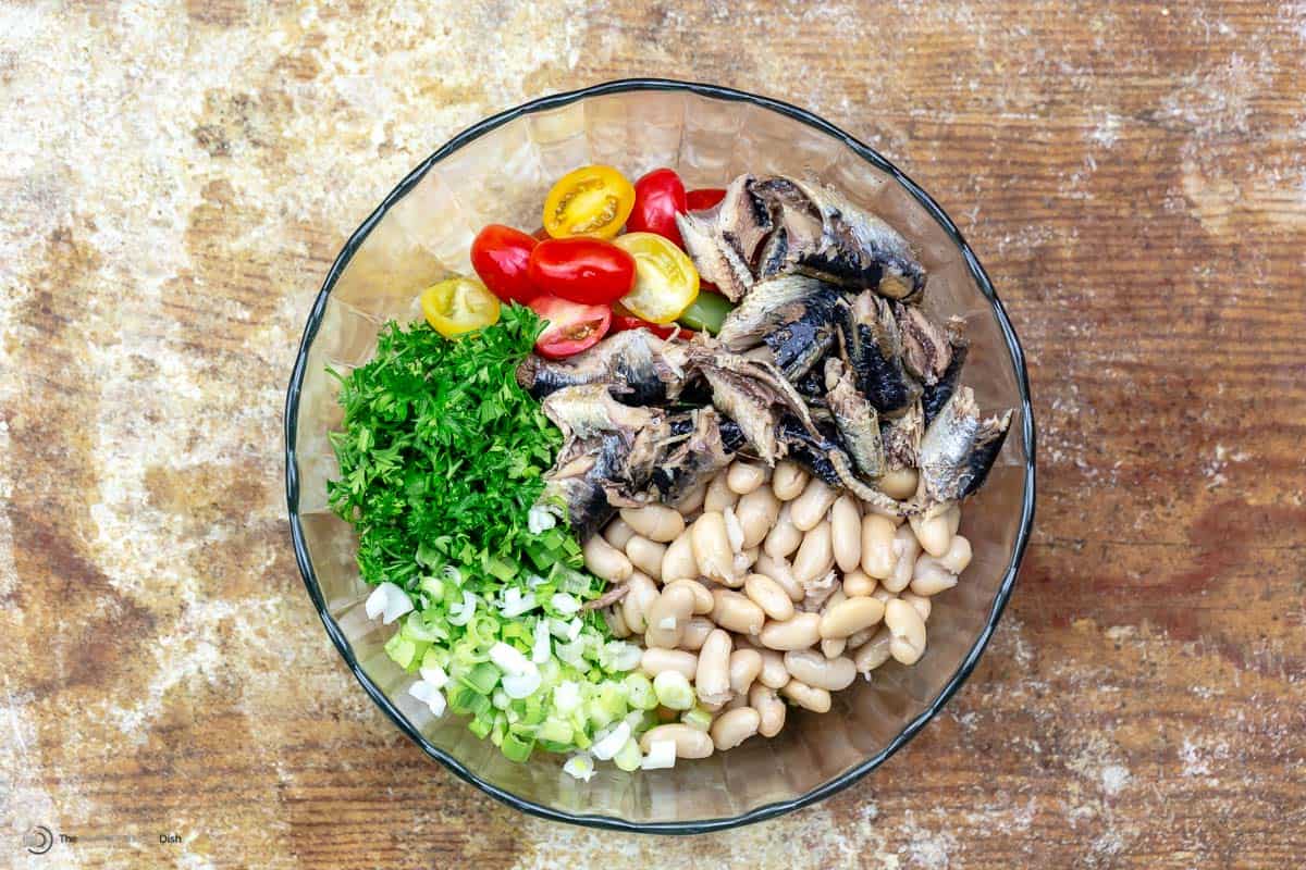 White bean and sardine salad ingredients in a white bowl