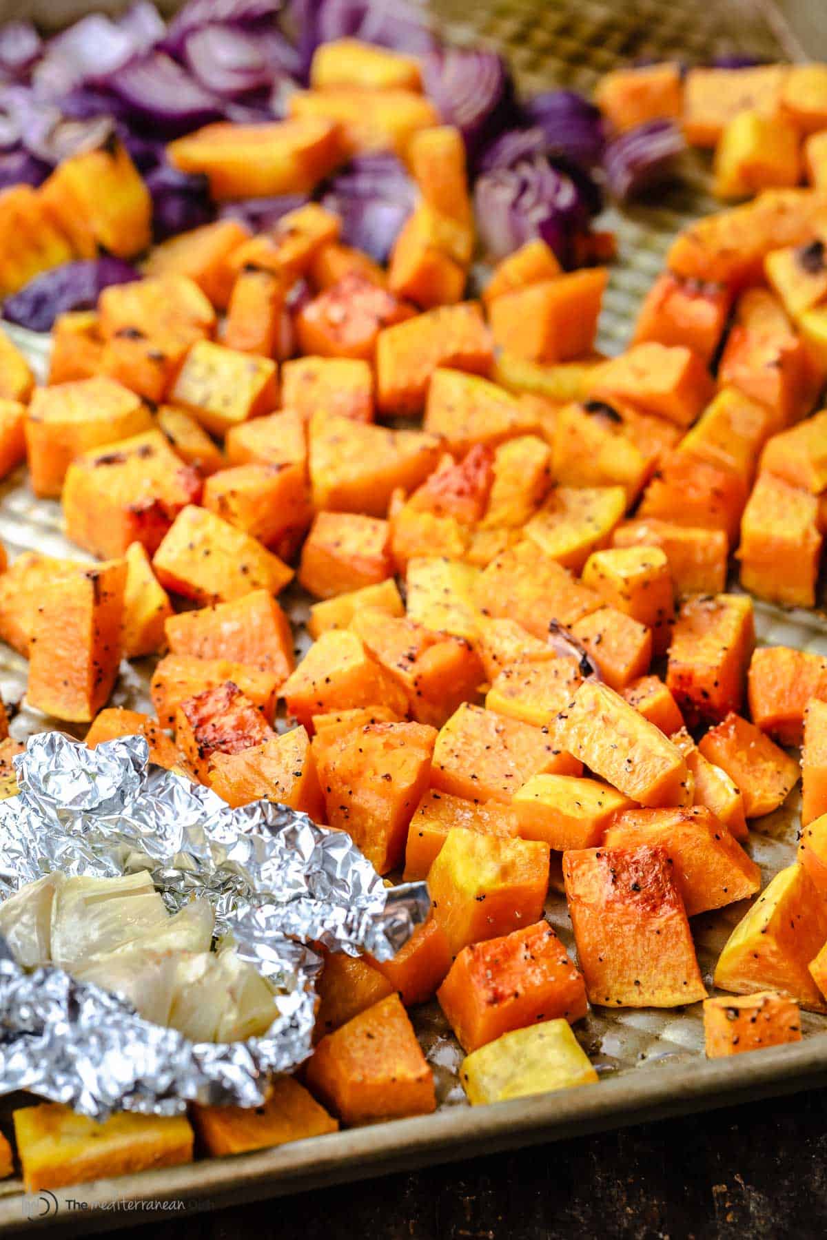 Roasted butternut squash pieces on a baking dish