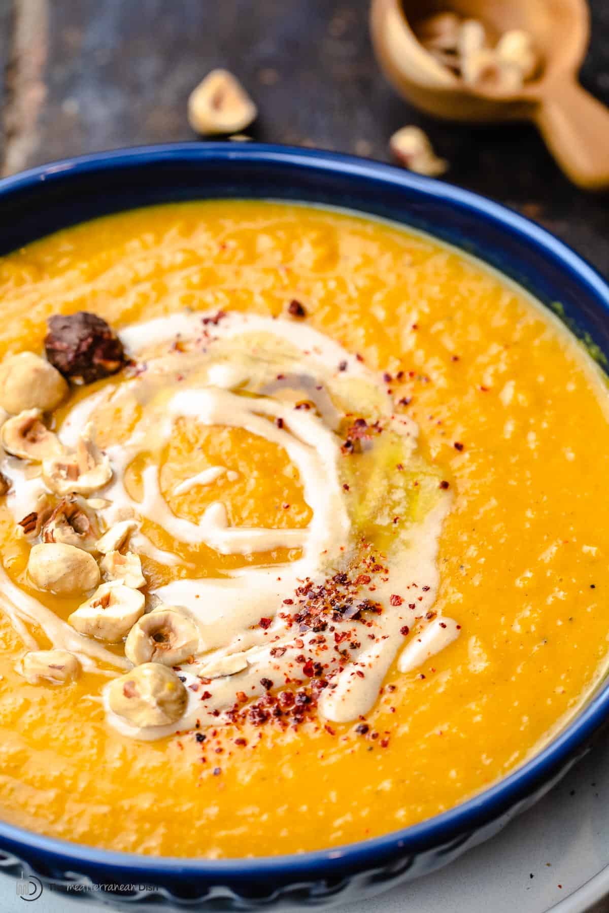 Overhead view of butternut squash soup topped with tahini and honey