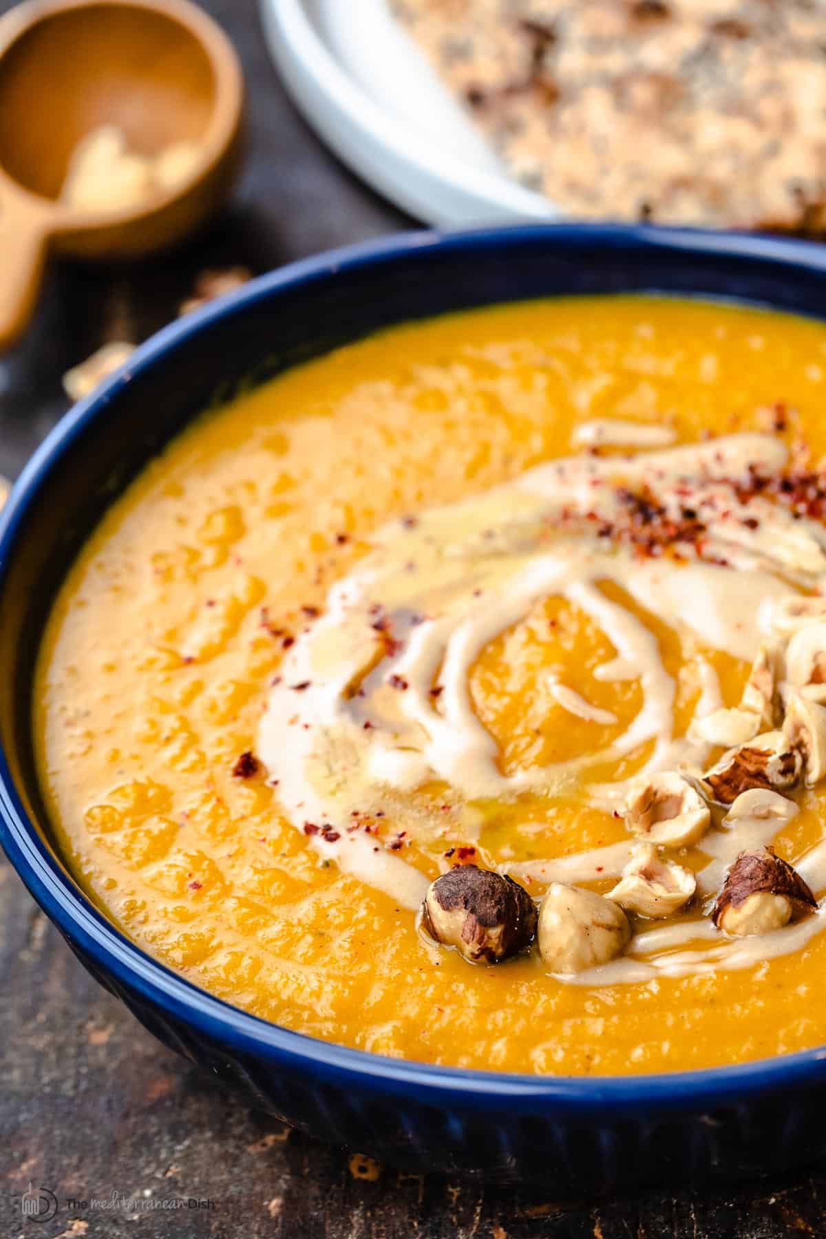 A bowl of roasted butternut squash soup with honey and tahini