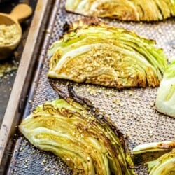 Charred cabbage wedges on a baking sheet