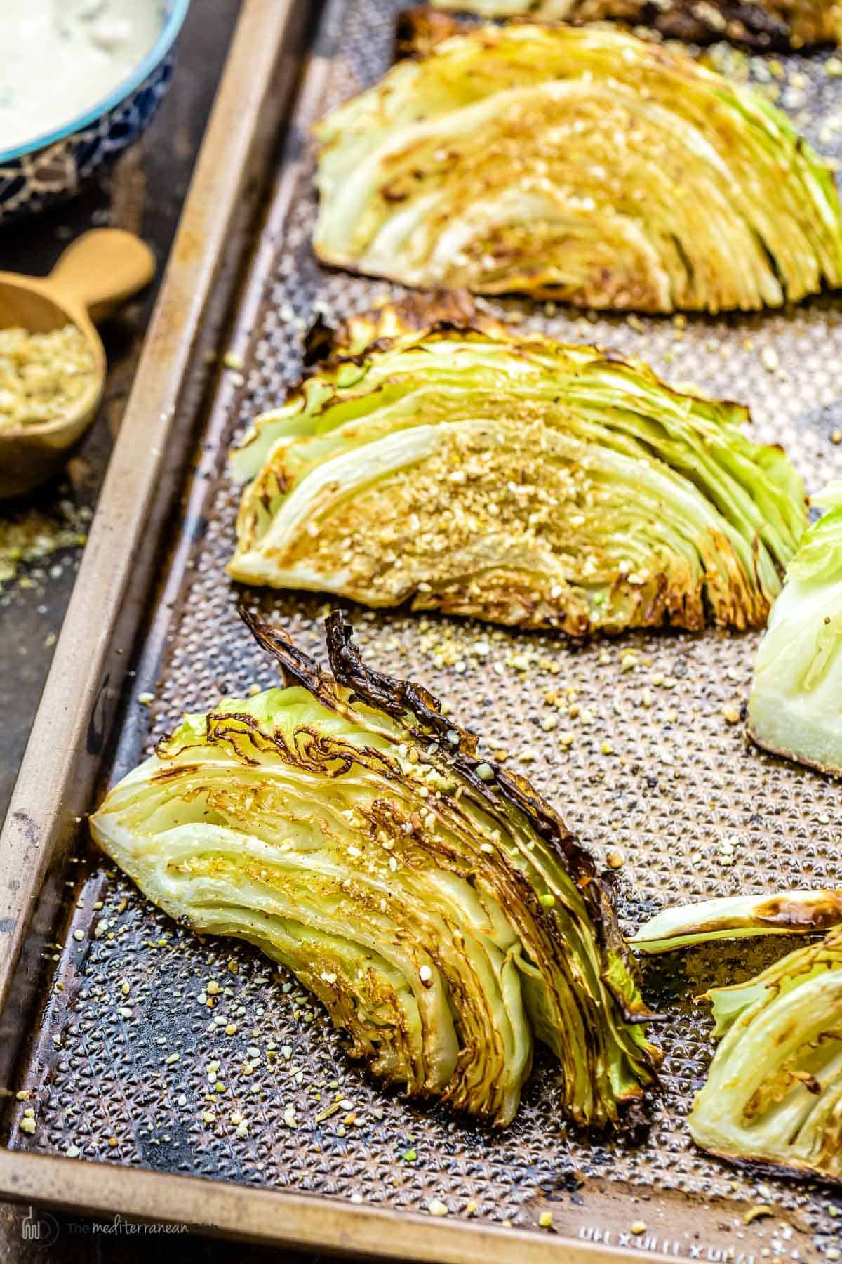 Charred cabbage wedges on a baking sheet