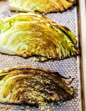 Close-up of two roasted cabbage wedges on a baking sheet cabbage wedges on a baking sheet