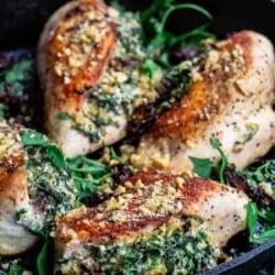 chicken breasts, stuffed with spinach, ricotta, and walnuts in a cast iron skillet