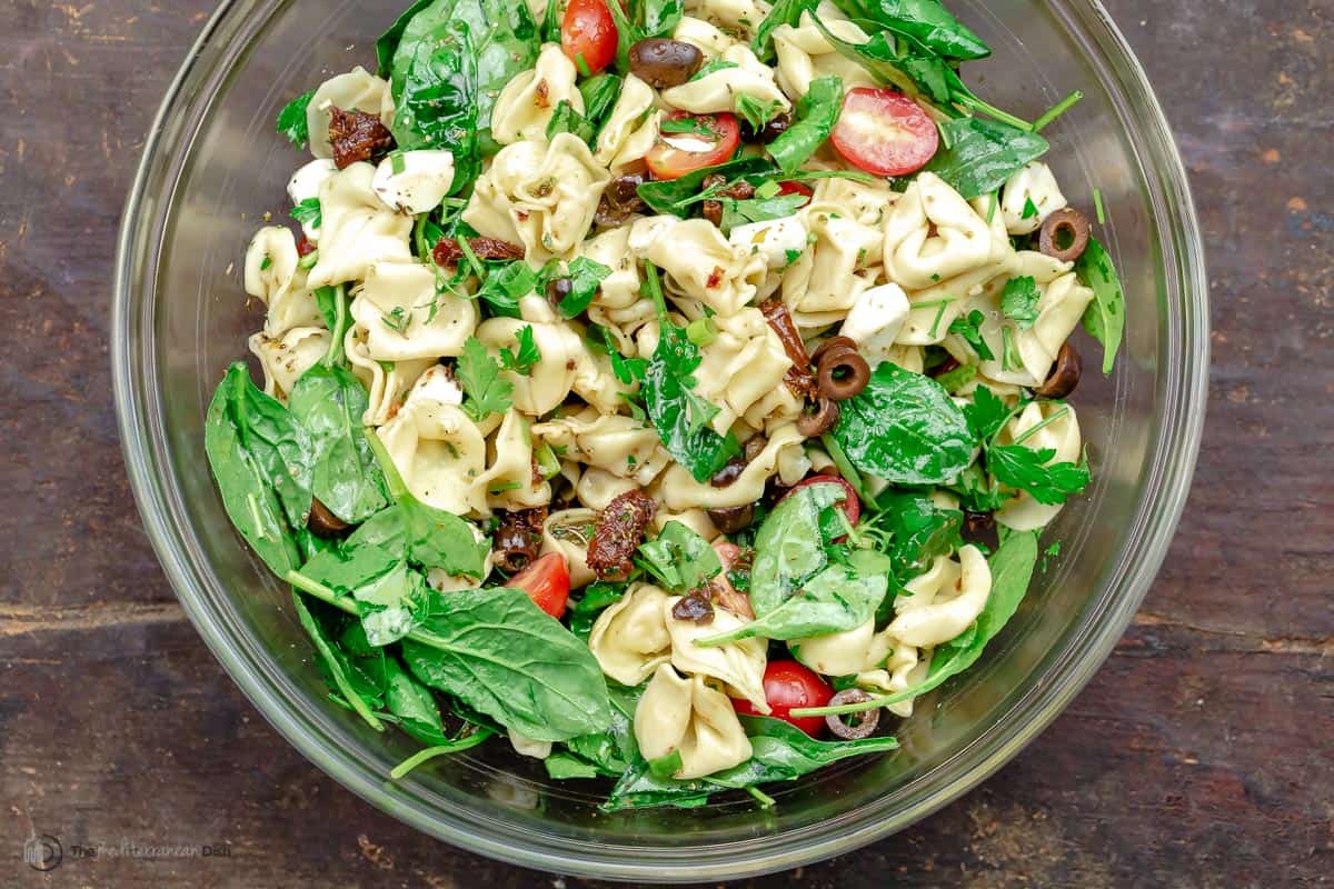 Spinach tortellini salad in a glass bowl