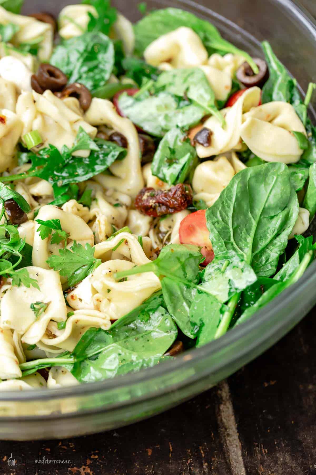 Close-up of Mediterranean tortellini salad in a glass bowl