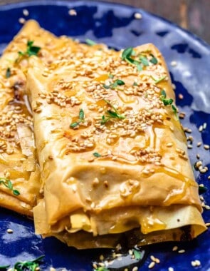 Close-up of baked feta with honey. Topped with toasted sesame seeds and fresh thyme