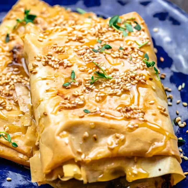 Close-up of baked feta with honey. Topped with toasted sesame seeds and fresh thyme
