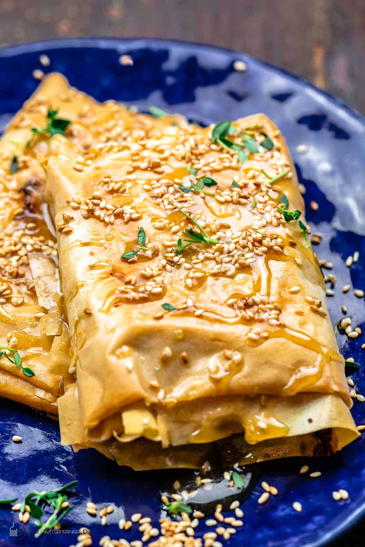 Close-up of baked feta with honey. Topped with toasted sesame seeds and fresh thyme